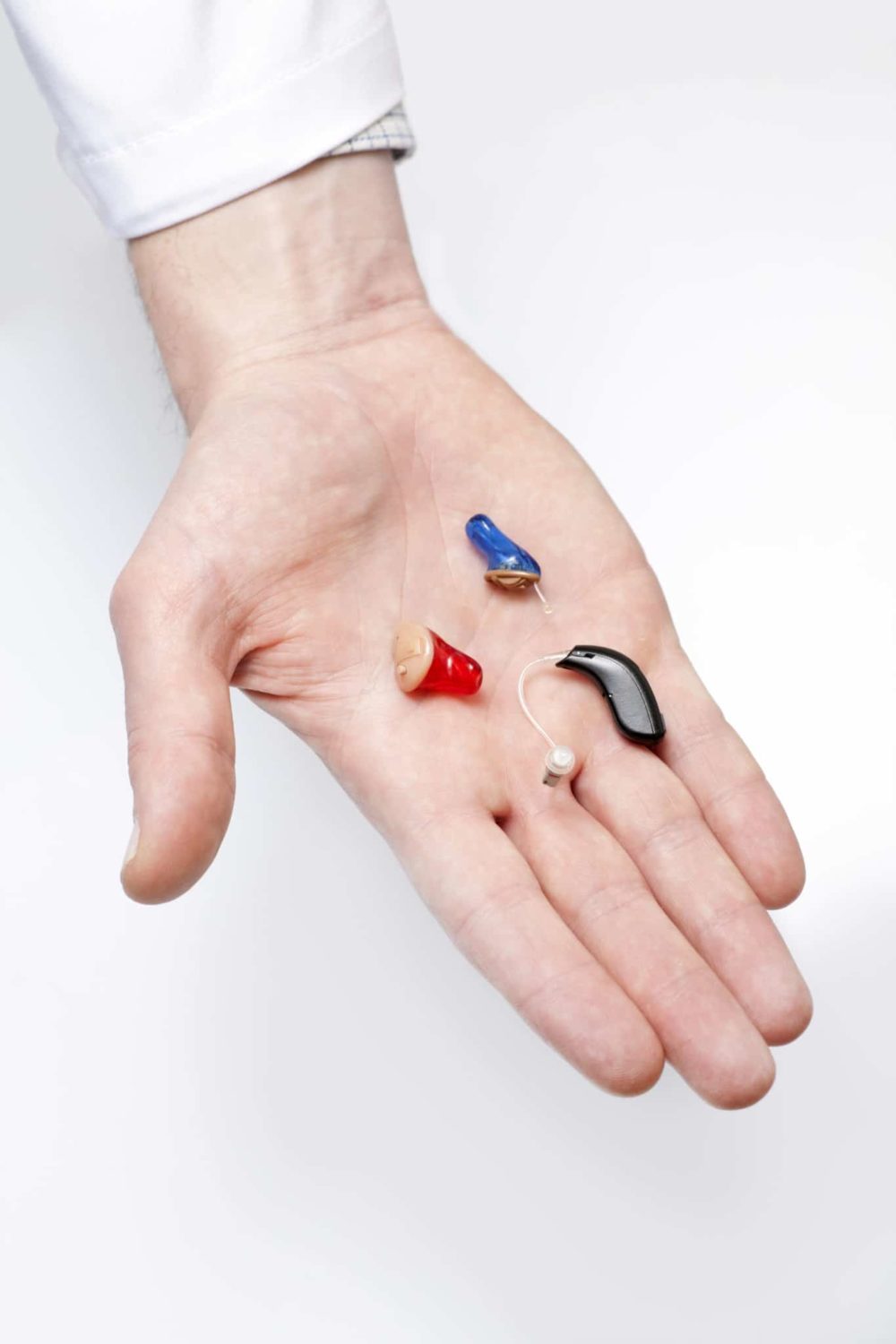 Hand holding variety of hearing aids in Cincinatti, Ohio office.