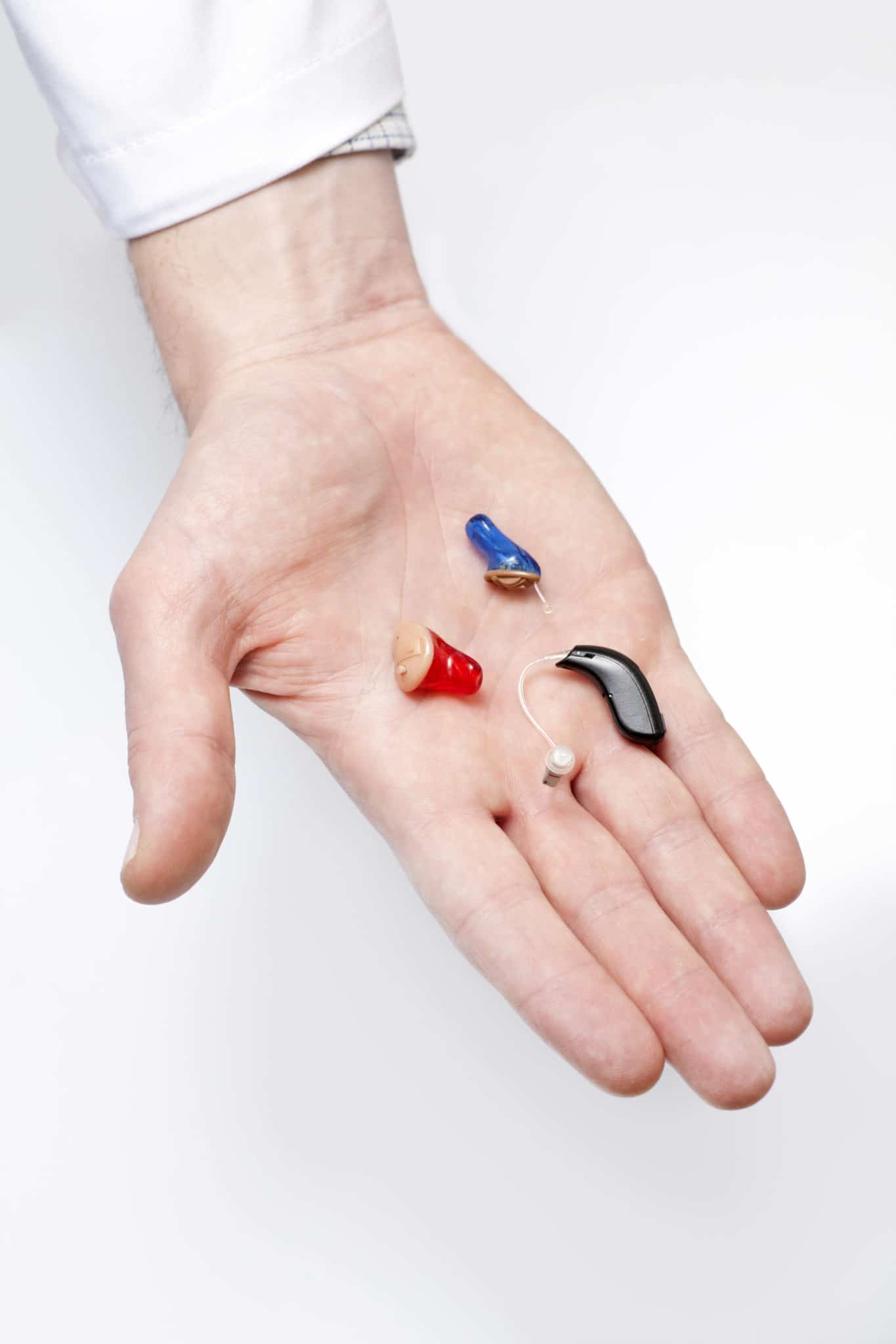 Hand holding variety of hearing aids in Cincinatti, Ohio office.